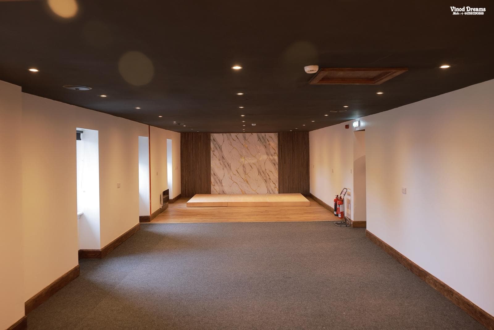 Wide view of the event hall showing its open floor and raised stage